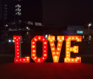 Large illuminated marquee letters spelling "LOVE" at a romantic Dallas wedding reception, creating a glamorous backdrop for photos. Rented from Dallas Event Rentals.